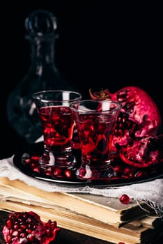 Alcoholic cocktail with pomegranate fruit on metal tray
