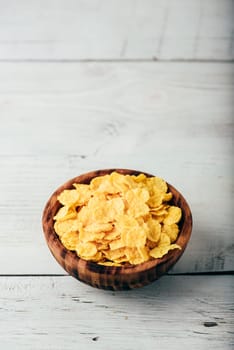 Breakfast cornflakes in a wooden rustic bowl