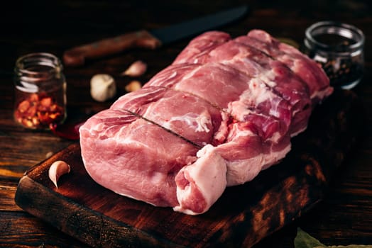 Pork loin joint on chopping board with spices