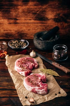 Pork loin steaks with ground spices on baking paper