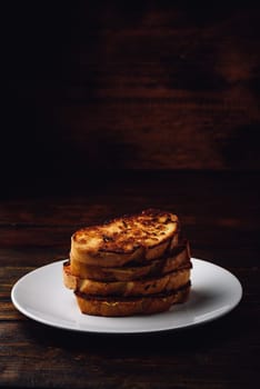 French toasts on white plate over wooden surface