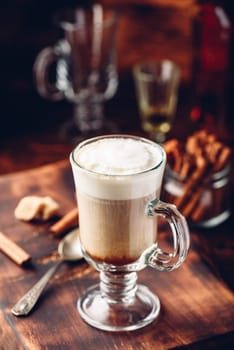 Irish coffee in drinking glass on wooden surface
