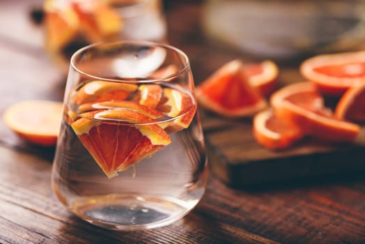 Infused water with bloody oranges in drinking glass