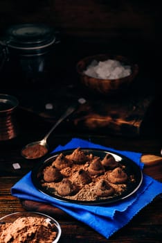 Homemade truffles with dark chocolate on metal tray