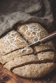 Sliced homemade rye bread on cutting board with knife