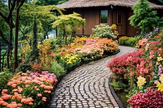 A path through a garden with a stone walkway and orange flowers. The flowers are in full bloom and the path is lined with green plants