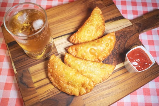 Homemade Brazilian Pastel with ketchup and a glass of Guarana. Typical Brazilian.