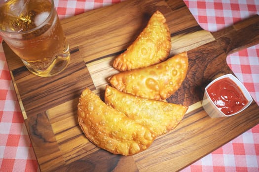 Homemade Brazilian Pastel with ketchup and a glass of Guarana. Typical Brazilian.
