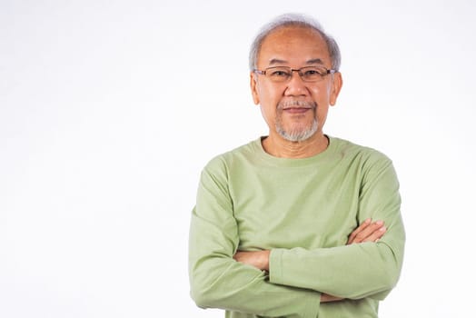 Portrait Asian grey haired smiling senior man with arms crossed studio shot isolated on white background, elderly arms folded lifestyle freedom relax retirement concept