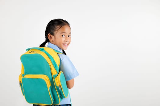 Portrait Back Asian smiling young girl kids kindergarten holding a green and yellow backpack studio shot isolated white background, happy cute little schoolgirl wears school uniform, back to school