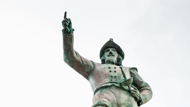 Columbus statue pointing at horizon on marble pedestal with map on white background - St. Augustine, Florida USA 03.15.2024.