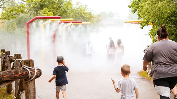 Family Fun In The Cooling Water Mist On A Hot Summer Day At The Amusement Park Toronto ON Canada - 22.12.22.