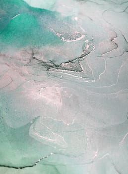 An abstract painting of green and silver ink swirling together in a fluid, organic pattern.