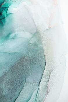 A close-up abstract image of green and white ink swirling together, creating a delicate and mesmerizing pattern. The colors blend seamlessly, resulting in a visually captivating artwork.