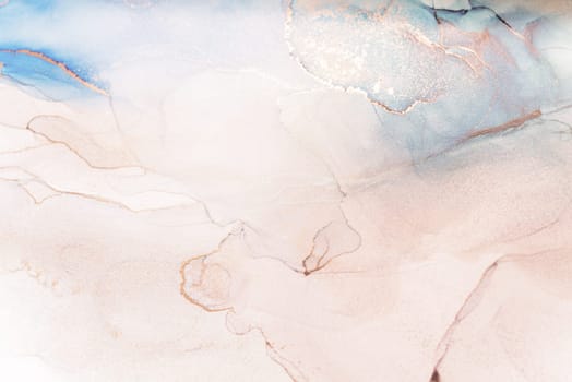 A close-up image of a delicate abstract art piece created using ink. The background is primarily white with blue and pink hues swirling through it, and fine gold lines tracing the shapes.