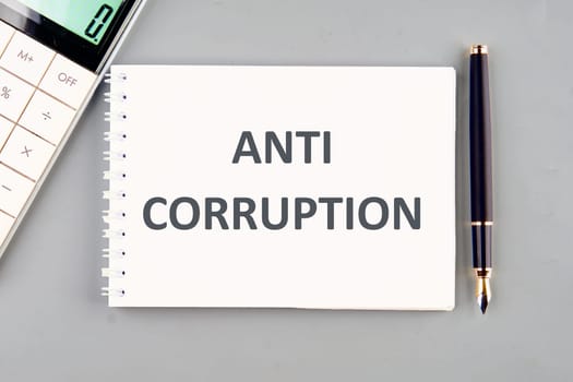 Anti money laundering business and government concept. ANTI CORRUPTION in a notebook on a gray background