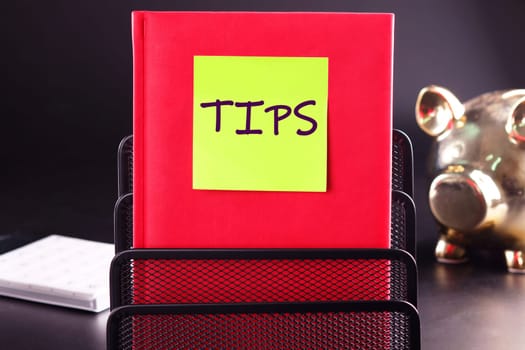 TIPS written on the sticker on the red business book