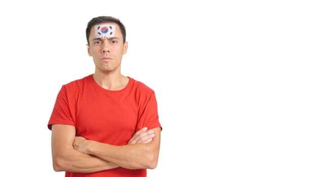 Dignified and serious man with south korean flag painted on face looking the camera with dignity