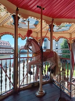 beautiful horses on rotating carousel High quality photo. Mobile vertical photo. Amusement park, kids fun, family time