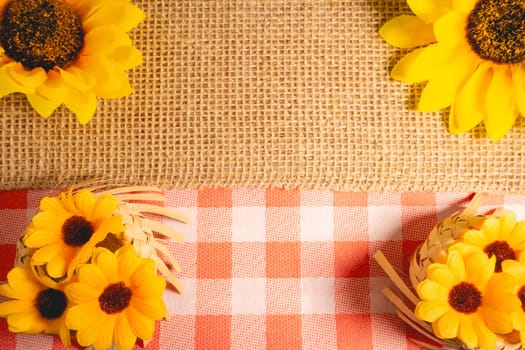 Decorative background for the Brazilian holiday Festa Junina. With sunflowers and straw hats.