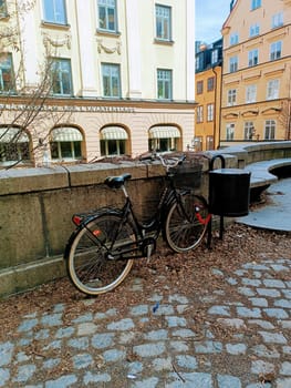 Black bicycle staying near the stone fence in old city Stockholm Sweden . High quality photo. Mobile vertical photo