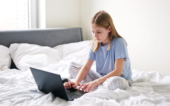 Cute Preschool Girl Surfing The Internet Early In The Morning On The Weekend While In Bed
