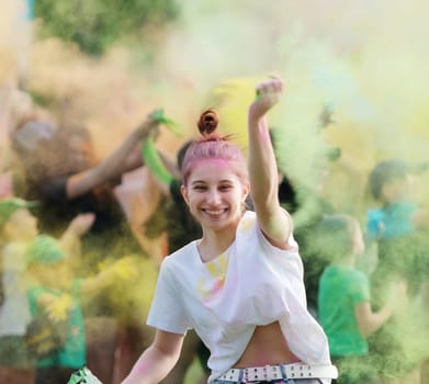 Girl Dancing Amidst Vibrant Colored Powder On Holi Festival