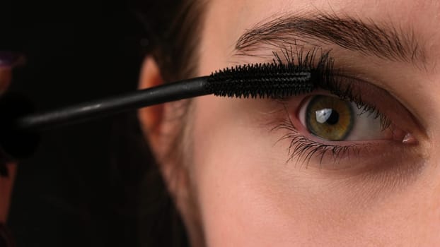 Girl Applying Black Mascara To Her Long Eyelashes