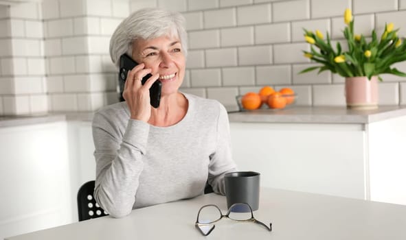 Cheerful Elderly Woman Chatting On The Phone With A Smile