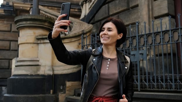 Attractive Woman Strolls Through European City, Taking A Selfie