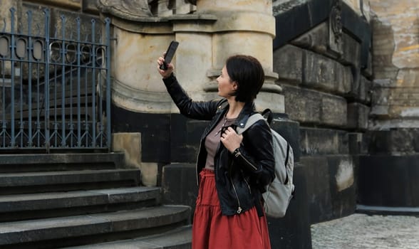 Attractive Woman Strolls Through Touristic Places Of Dresden, Capturing Photos Of Sightseeings