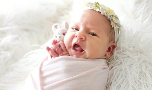 Adorable Newborn Baby Wrapped In A Blanket Holding A Knitted Toy