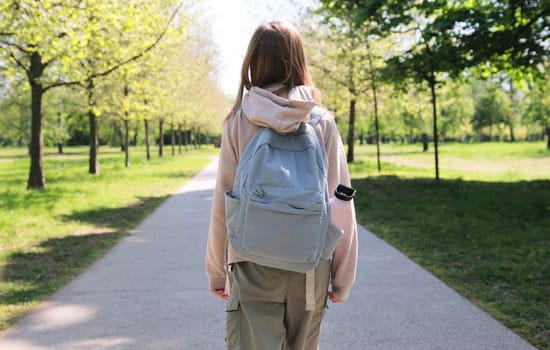 Small Schoolgirl Comes Back From School Classes Through Summer Park