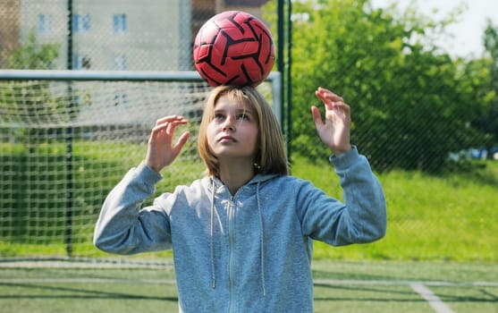 Small Girl Soccer Player Practicing With Ball On A Soccer Field