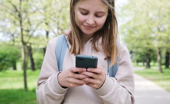 Adorable Small Girl Using A Smartphone In The Park