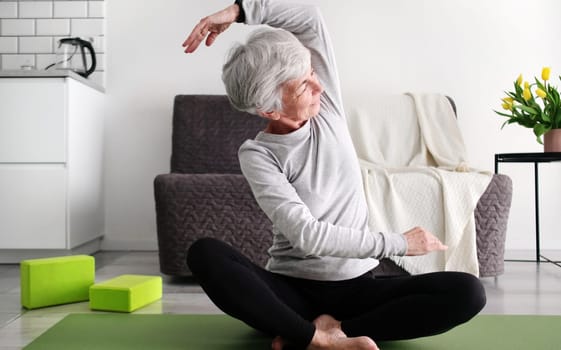 Elderly Woman With Grey Hair Doing Fitness And Yoga Exercises At Home