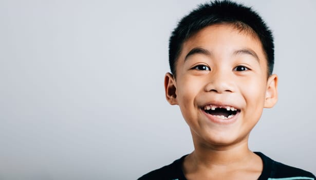 Boy grinning lost upper tooth gap showing in wide smile. Child dental development isolated on white. Joyful tooth fairy moment growth change. Children show teeth new gap, dentist problems