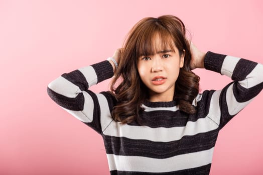 Asian happy portrait beautiful cute young woman standing angry and mad raising fist frustrated and furious while shouting with anger isolated, studio shot on pink background and copy space