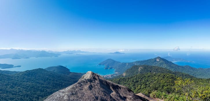 Panoramic seascape of islands in blue waters under a clear sky.