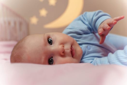 Peaceful baby lays on a bed next to a crib, surrounded by a cozy atmosphere and gentle tones.