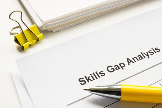 Stack of papers with skills gap analysis report.