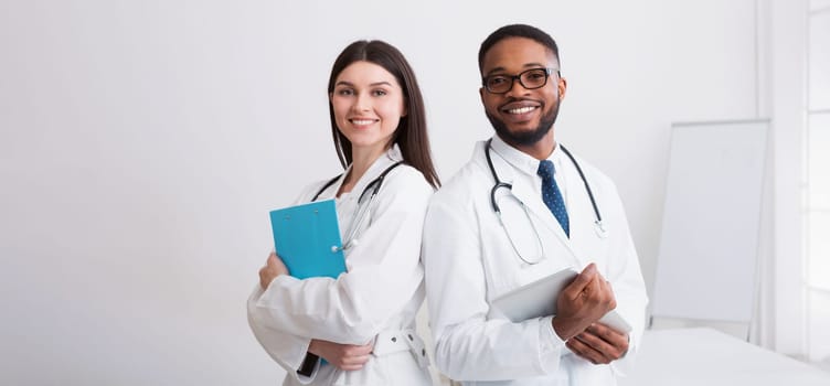 Two Doctors In White Coats Posing To Camera At Conference, Copy Space