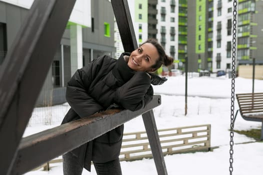 Weekend concept, brunette woman dressed in a black winter jacket walking on the street.