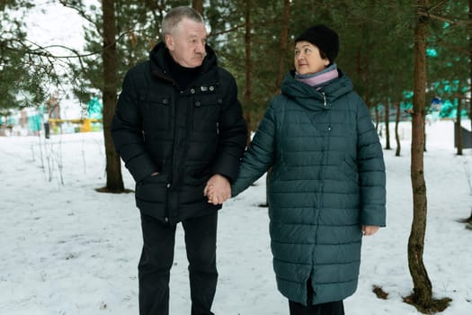 Happy elderly couple feels tenderness for each other while walking in the park.