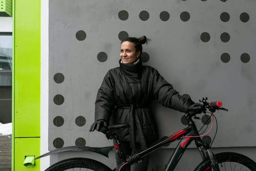 European young woman riding a bicycle on the street in winter.