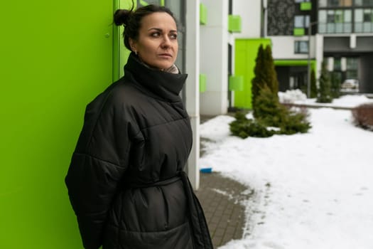 Portrait of a happy cute brunette woman walking in the city in winter.