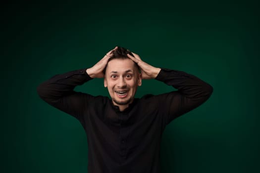 A man is standing with his hands on his head in an expression of distress or frustration. He appears to be deep in thought, contemplating a difficult situation or experiencing stress.