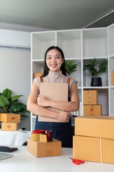 A young entrepreneur prepares parcel boxes for delivery in a modern office, showcasing the process of online ecommerce business and product shipping.