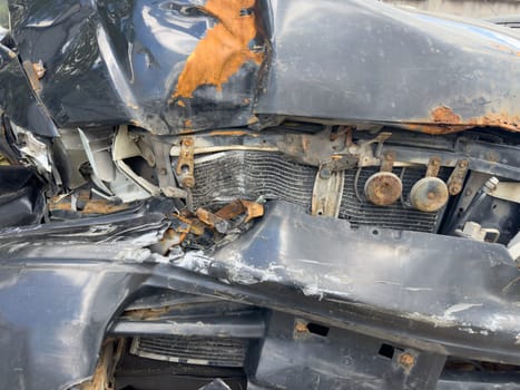 broken passenger car with rust close-up, standing outside, crumpled metal, broken headlight