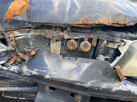 broken passenger car with rust close-up, standing outside, crumpled metal, broken headlight